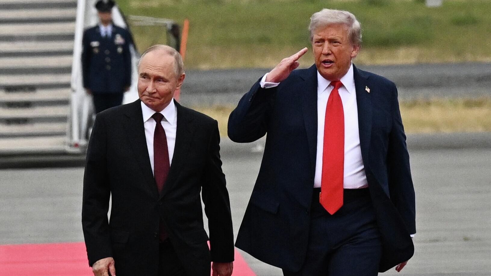 Президент России Владимир Путин и президент США Дональд Трамп идут по красной дорожке на Аляске