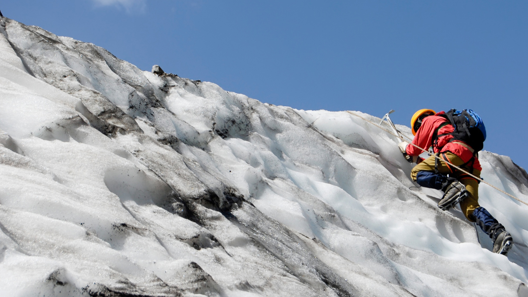 альпинист лезет на снежную гору