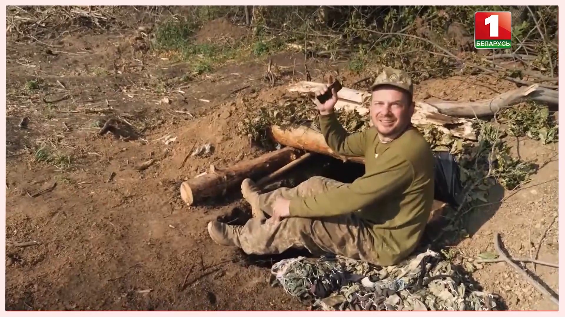 военный сидит на земле