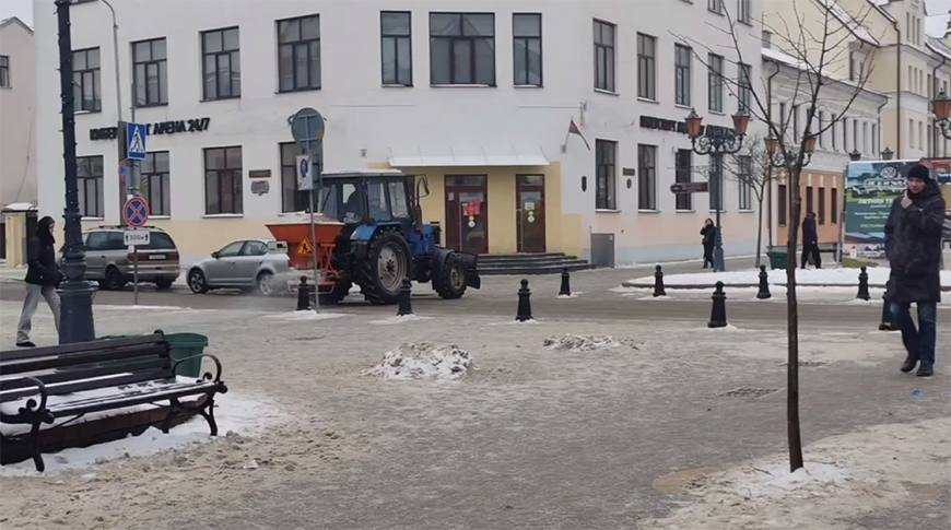 Работники ЖКХ обрабатывают противогололедными материалами дороги в Беларуси 