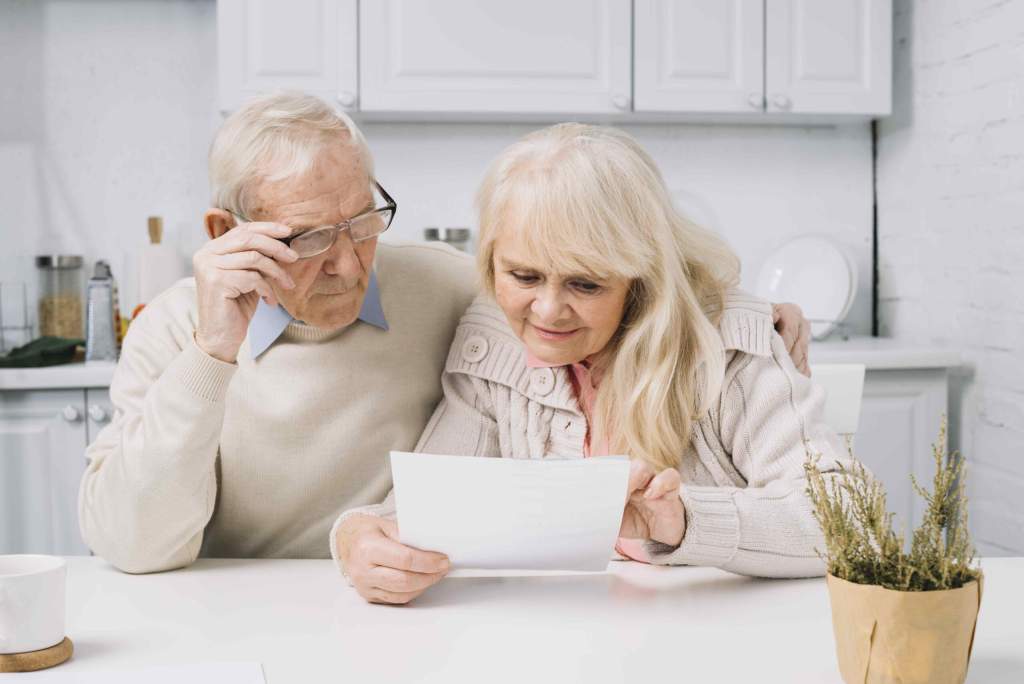 senior-couple-looking-paper-scaled.jpg